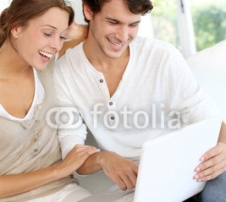 Happy_young_couple_using_laptop_computer_at_home_2.jpg